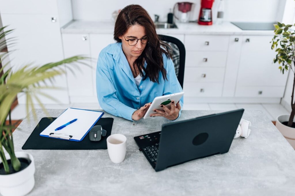 a woman using a tablet and laptop