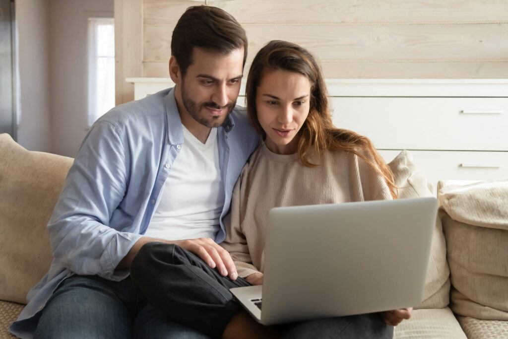 first-time homebuyer mistakes Couple looking at houses on a laptop | first-time homebuyer mistakes