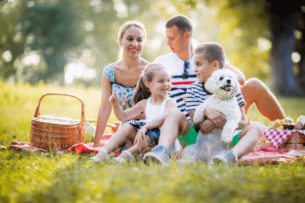 Dog-Friendly Parks Around Danville Family having a picnic with a dog nearby
