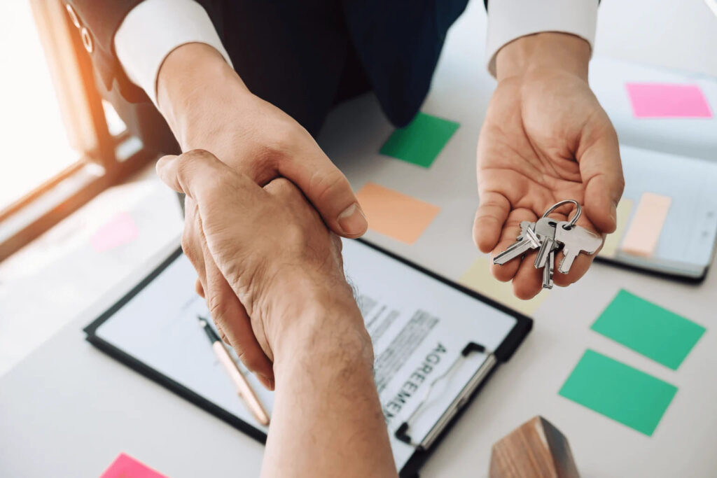 people shaking hands and giving a key