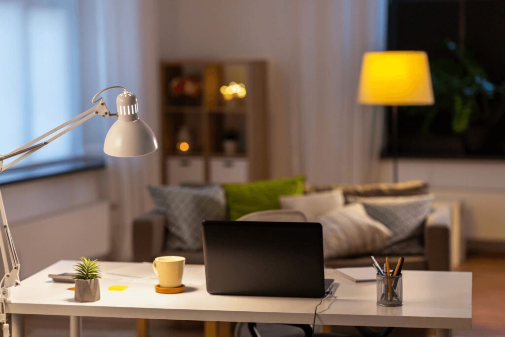 a laptop on a desk in the living room at night