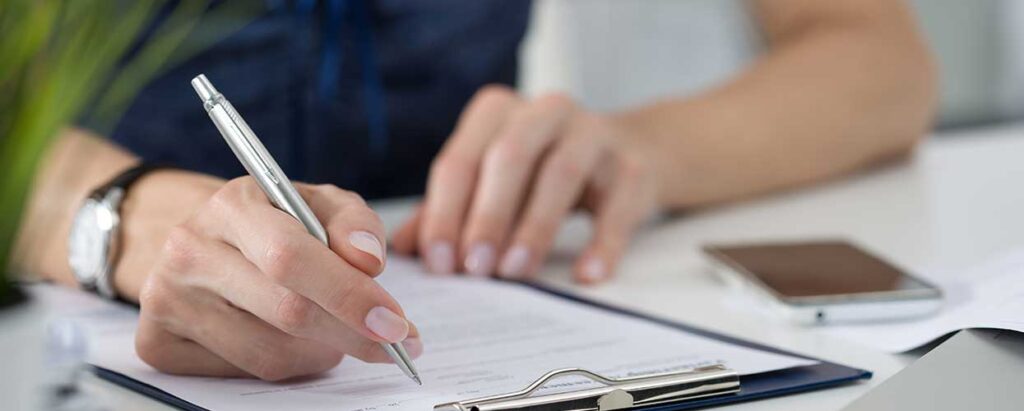 woman signing paper